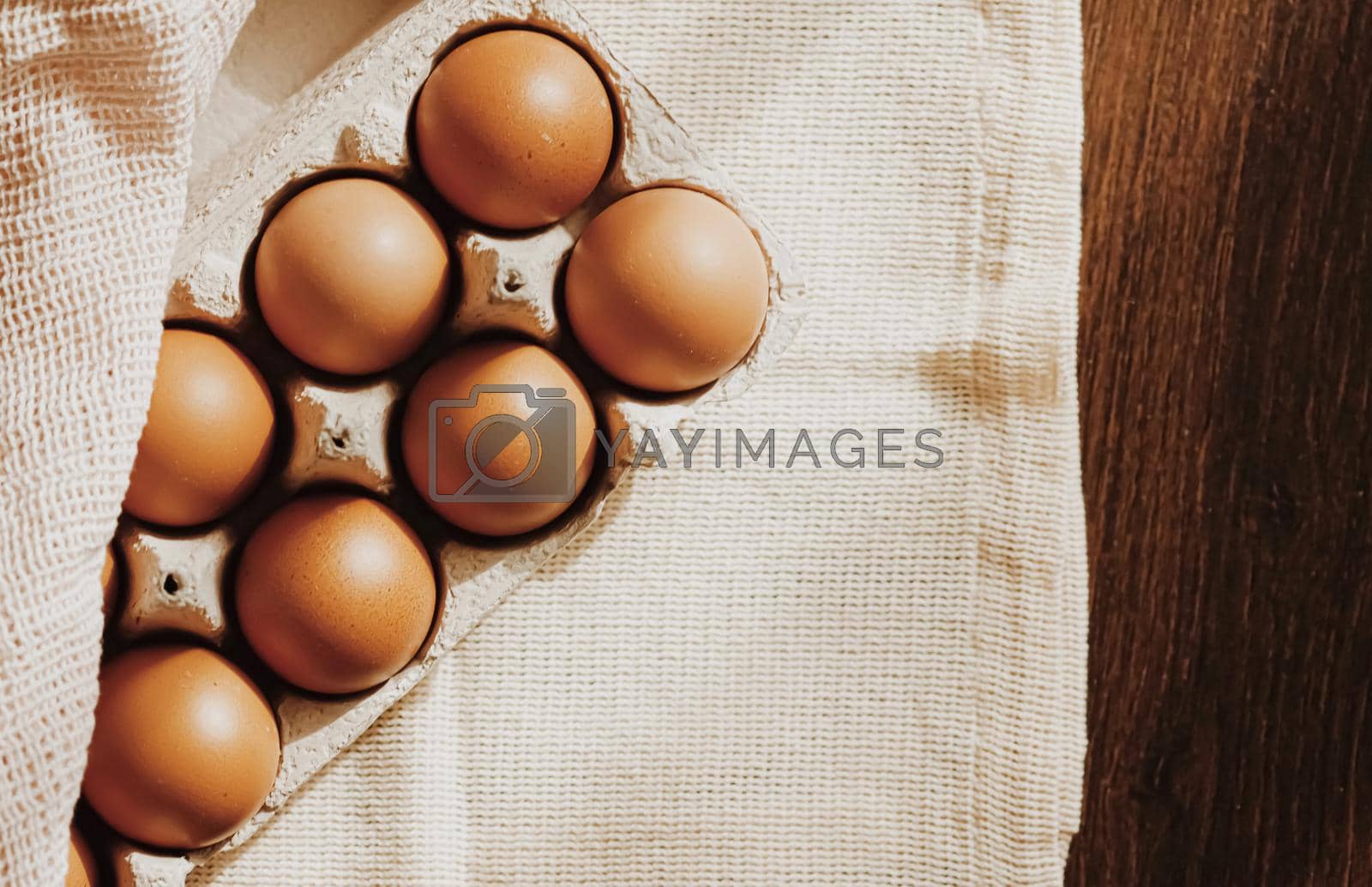 Royalty free image of organic farm eggs in egg box and rustic cloth napkins by Anneleven