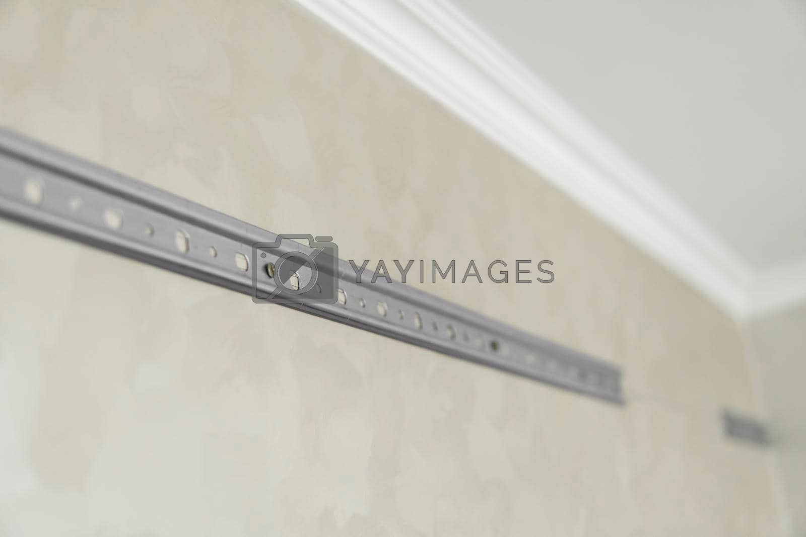 Royalty free image of Close-up of stainless steel mounting rail for mounting kitchen cabinets on a wall. by vovsht