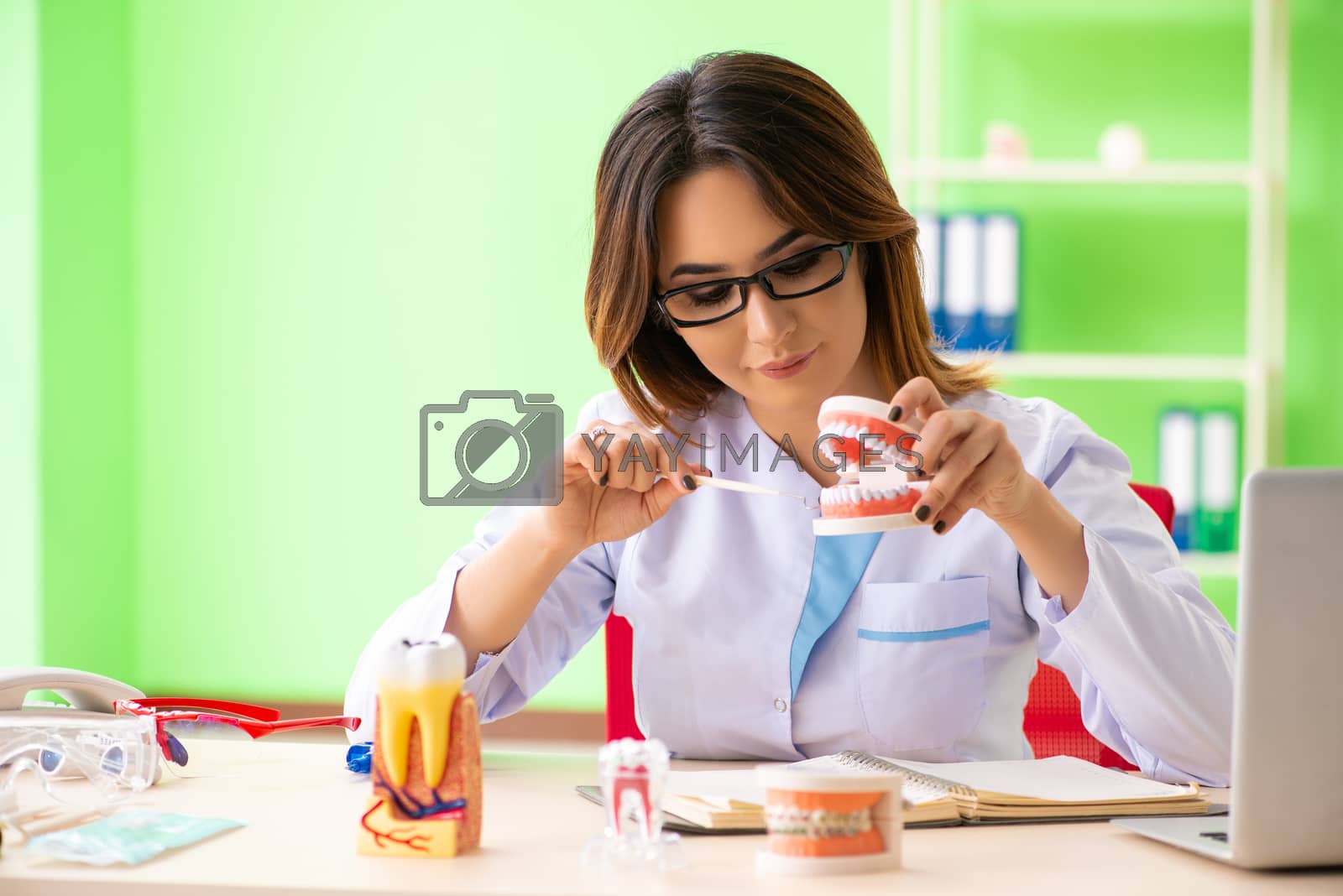 Royalty free image of Woman dentist working on teeth implant by Elnur