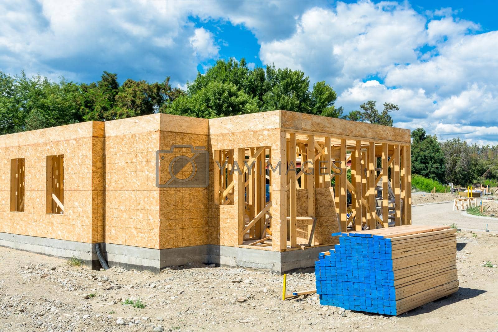 Royalty free image of Wooden frame of new building with lumber materials prepared for construction by Imagenet