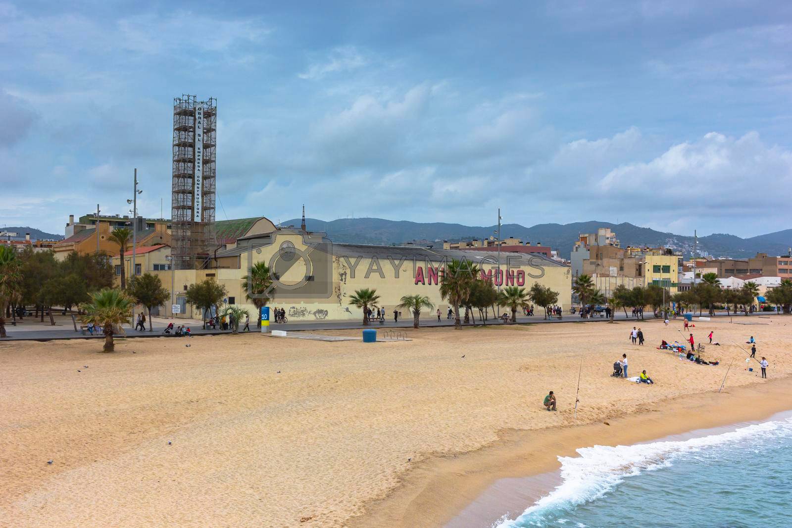 Barcelona beach in winter, with a calm sea and a cloudy blue sky
