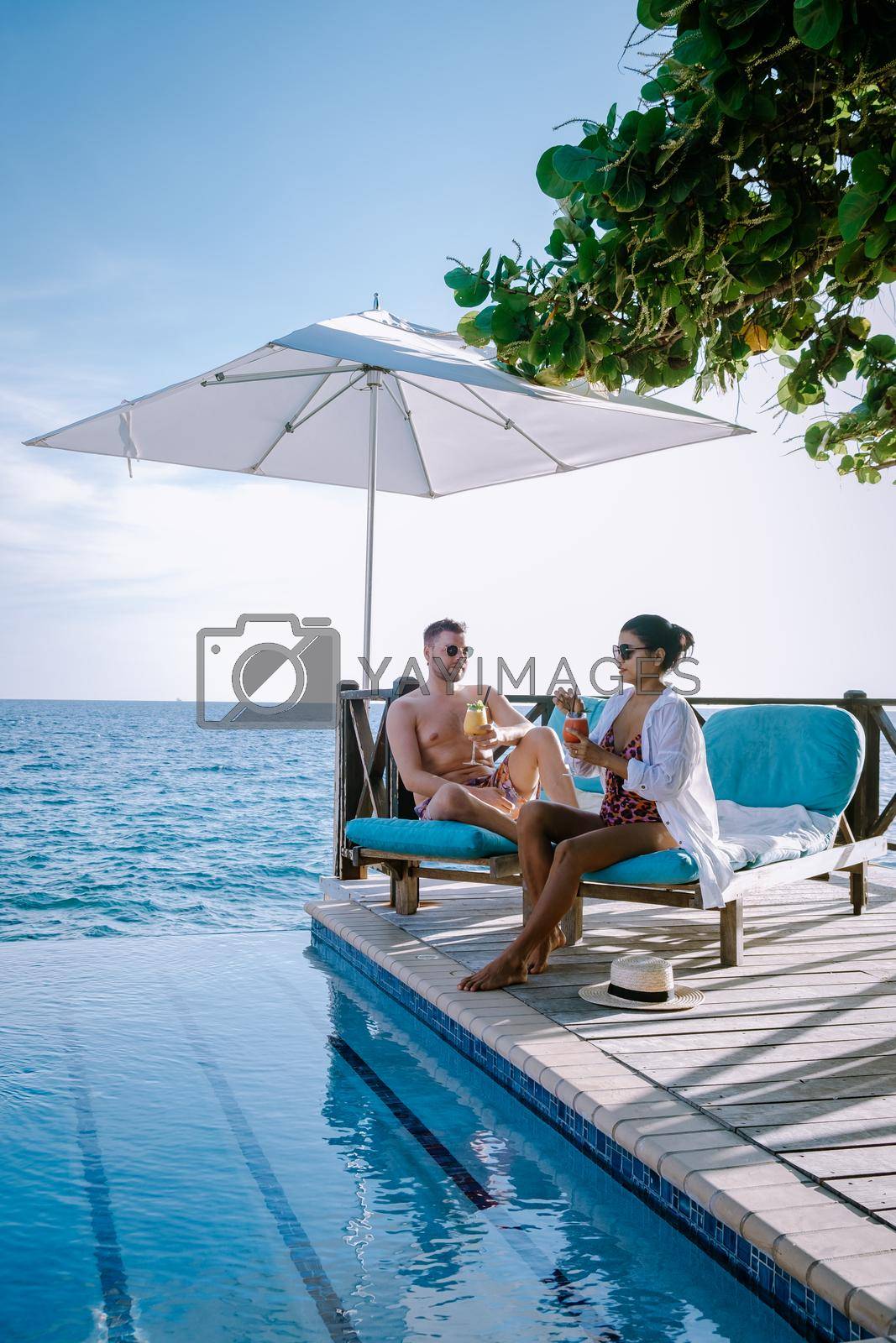 Royalty free image of Relaxing summer beach , Sunbathing deck and private swimming pool with Palm trees near beach and panoramic sea view at luxury house Curacao by fokkebok