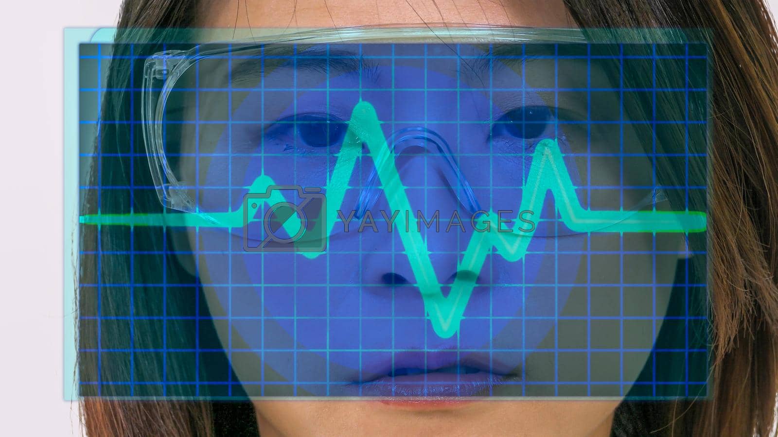 Royalty free image of Female Asian doctor looks at virtual medical EKG screen by imagesbykenny