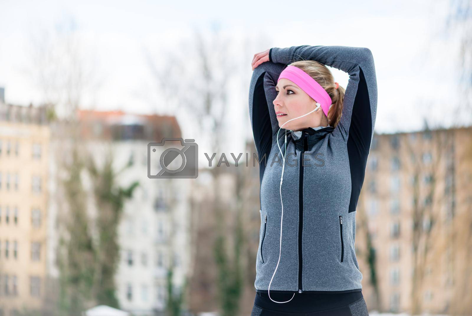 Royalty free image of Young woman stretching during sport training outdoor by Kzenon