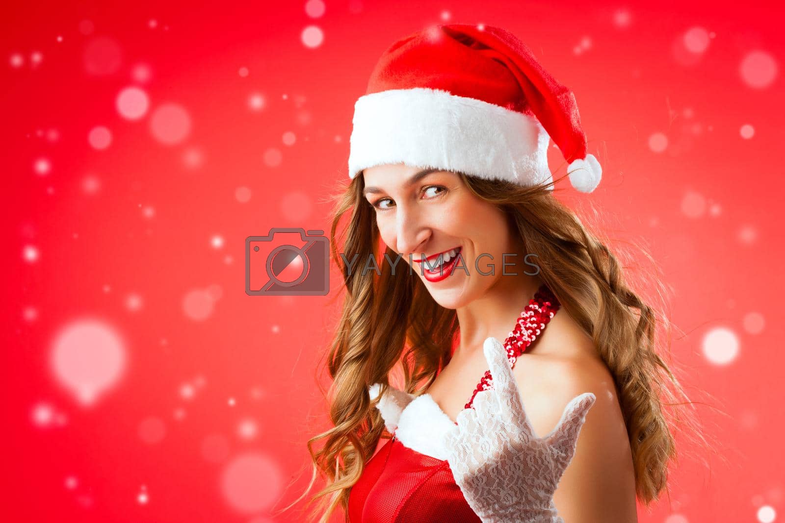 Royalty free image of Attractive young woman in Santa Claus costume alluring gesture by Kzenon