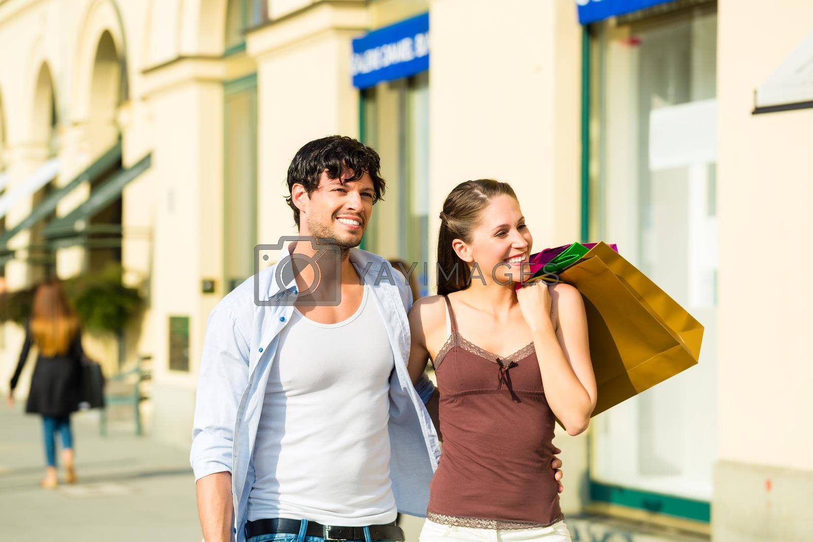 Royalty free image of Couple shopping and spending money in city by Kzenon