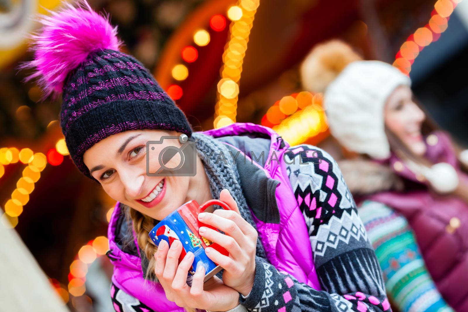 Royalty free image of Woman drinking eggnog on German Christmas Market by Kzenon