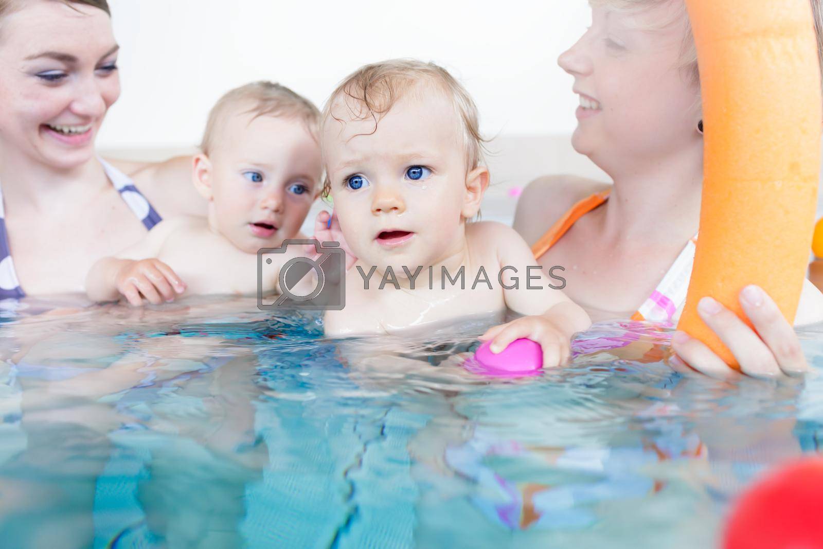 Royalty free image of Mothers being happy about their babies playing with each other by Kzenon