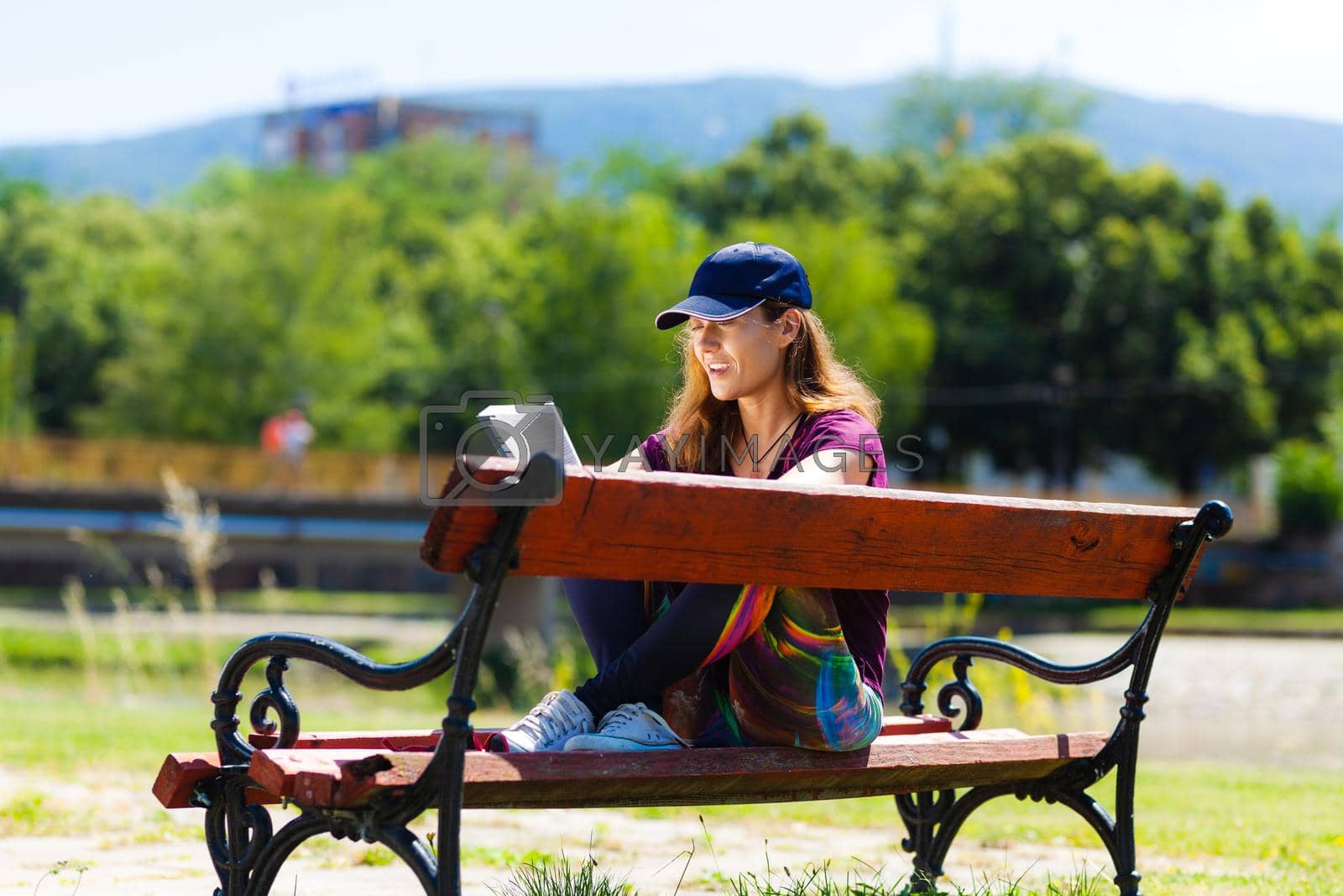 Royalty free image of girl on a bench reading a book by kokimk