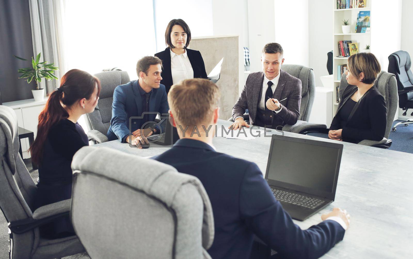 Royalty free image of Group of young successful businessmen lawyers communicating together in a conference room while working on a project by selinsmo