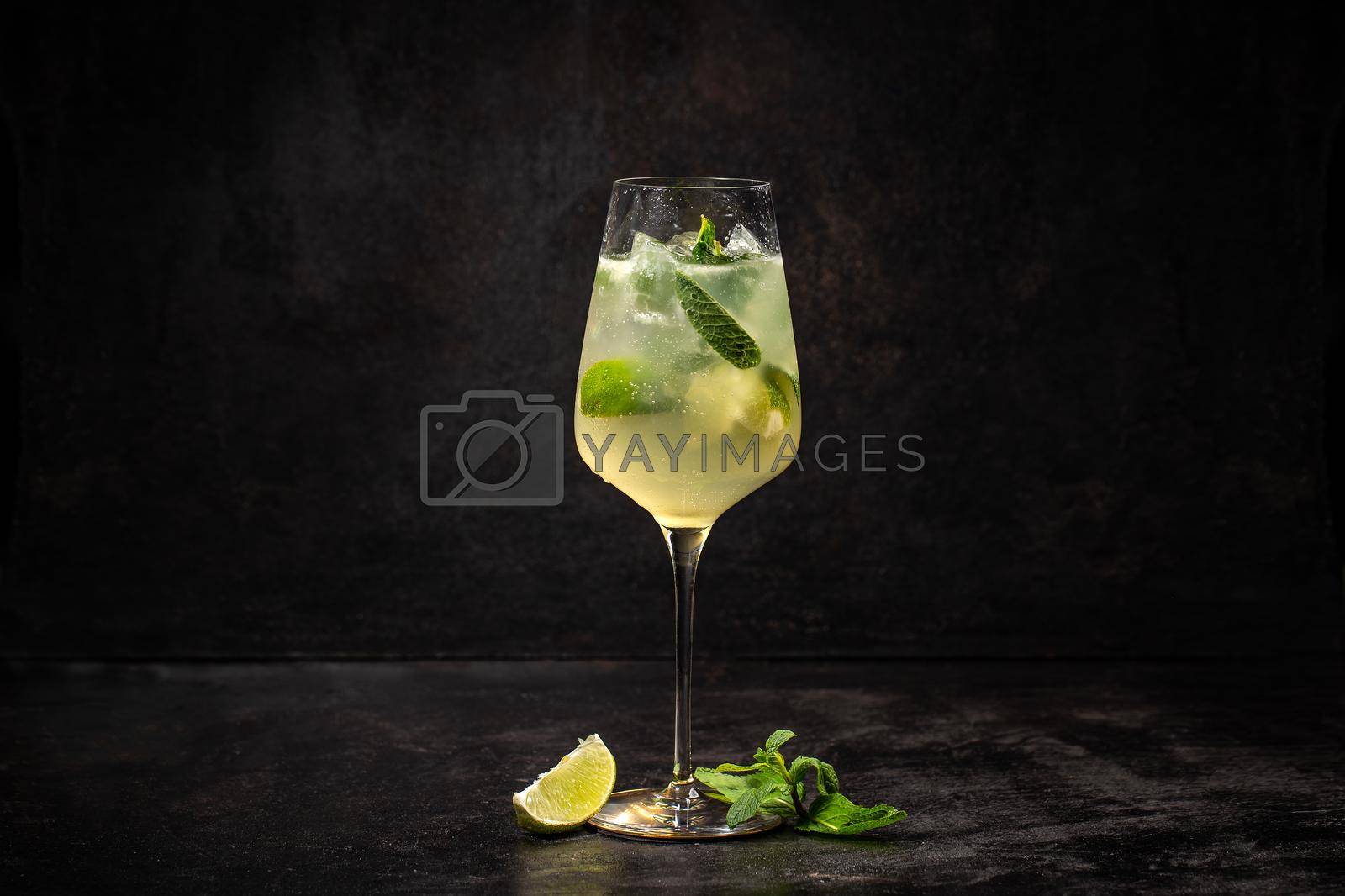 Summer cold drink with lemon, mint and ice on black background