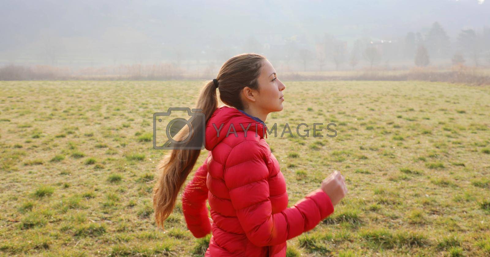 Royalty free image of Woman runner running in fall autumn fields. Healthy lifestyle concept. Active sportive people. by sergio_monti