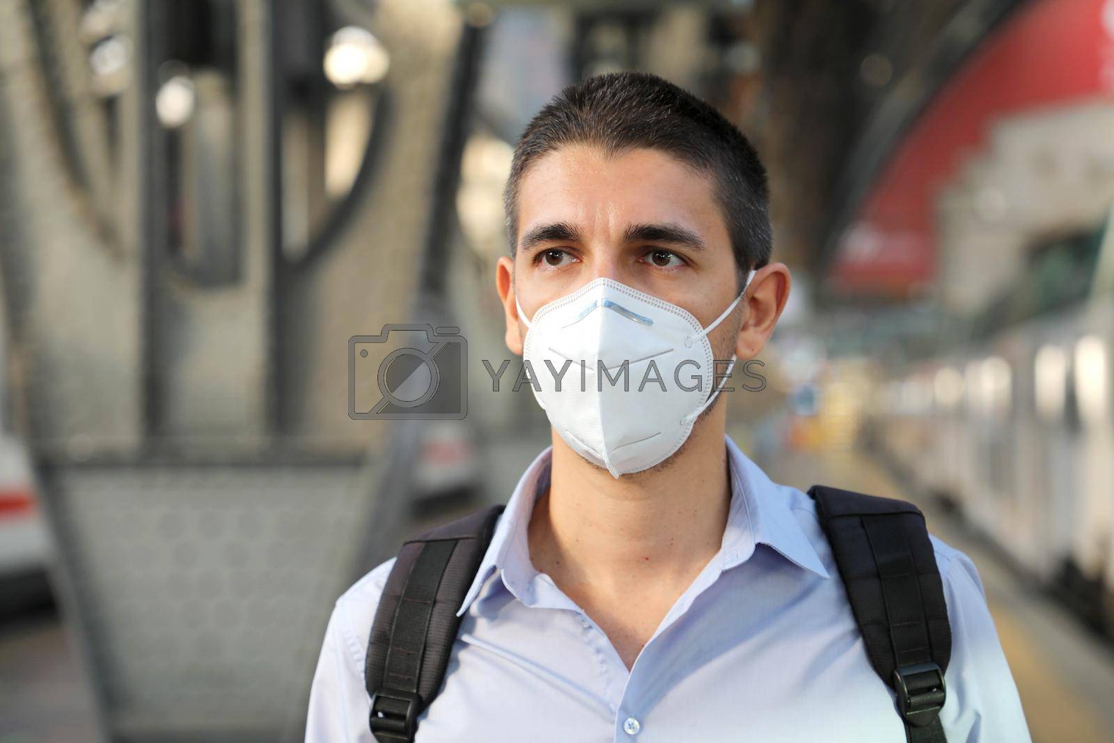 Close up of man waiting train with KN95 FFP2 protective mask at train station