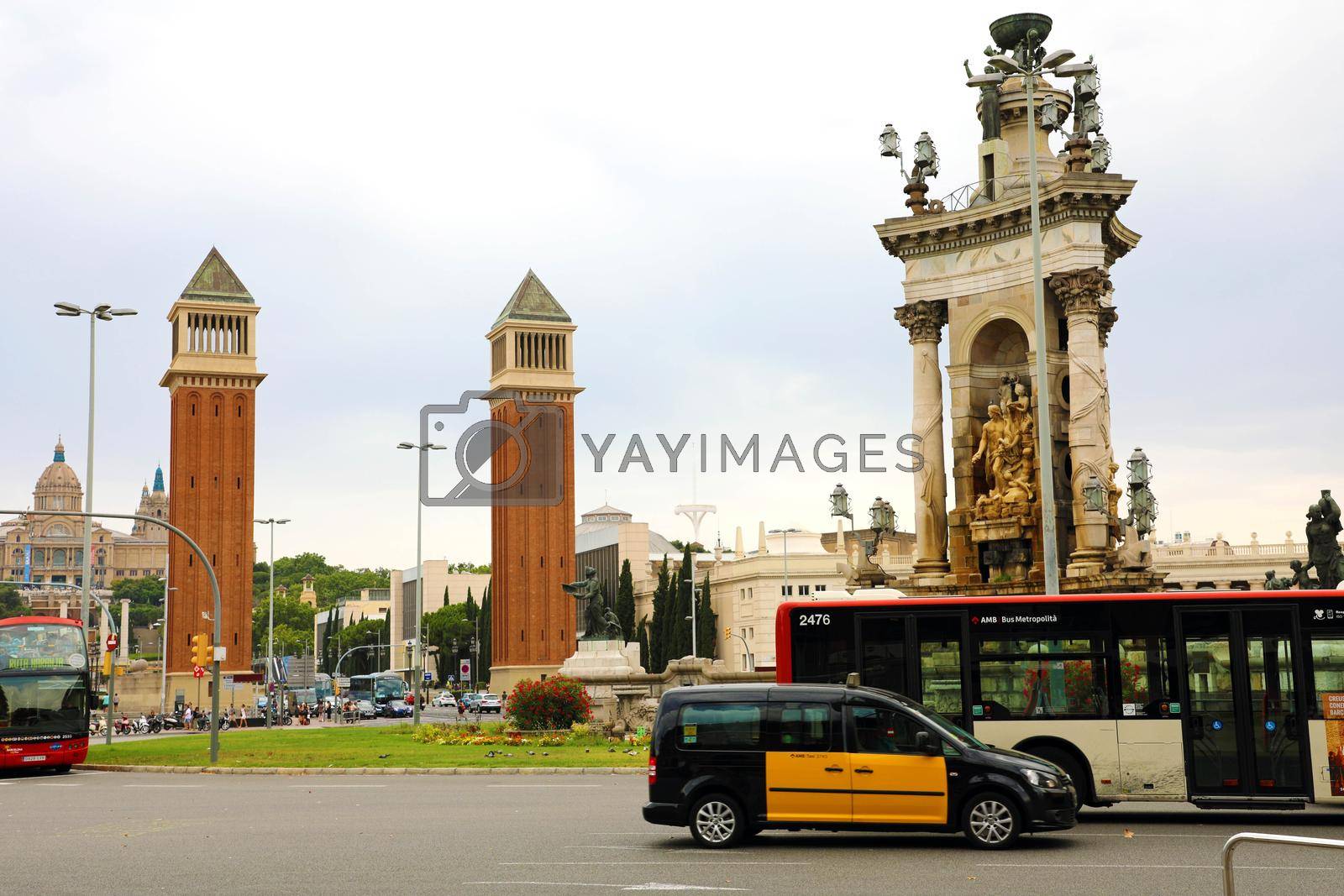 BARCELONA, SPAIN - JULY 13, 2018: Venetian towers in Placa d'Espanya square and the fountain with traffic cars, Catalonia, Spain