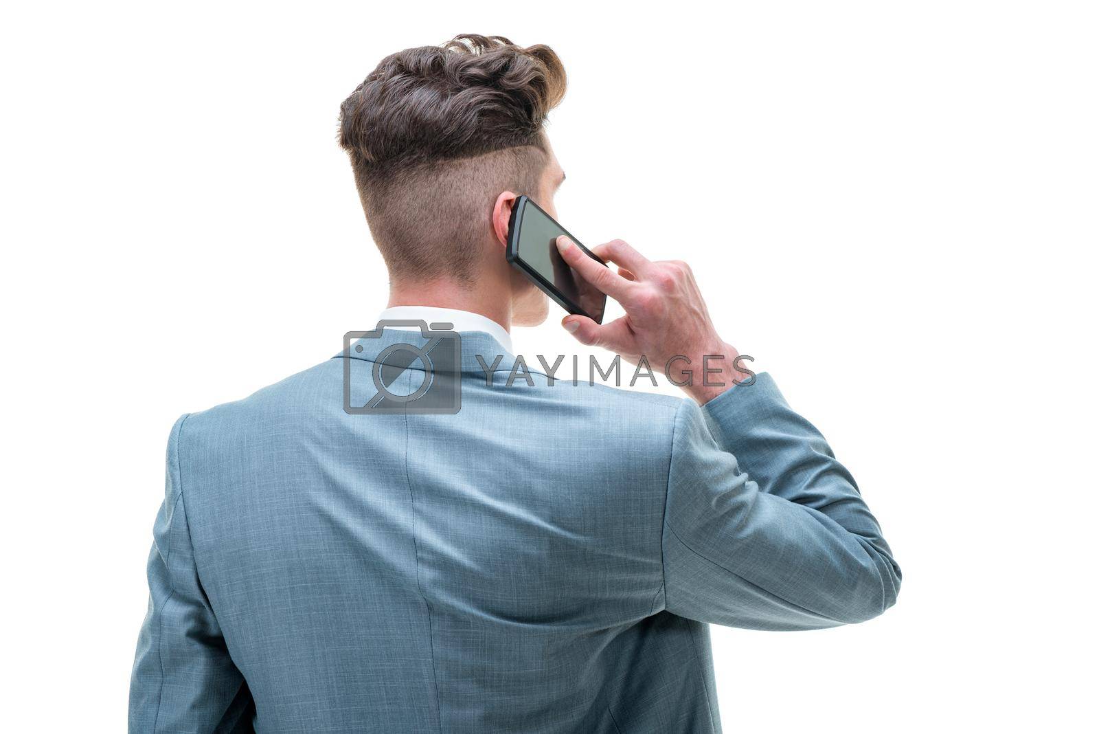 Rear view of a handsome man talking at the smartphone, isolated on white background.