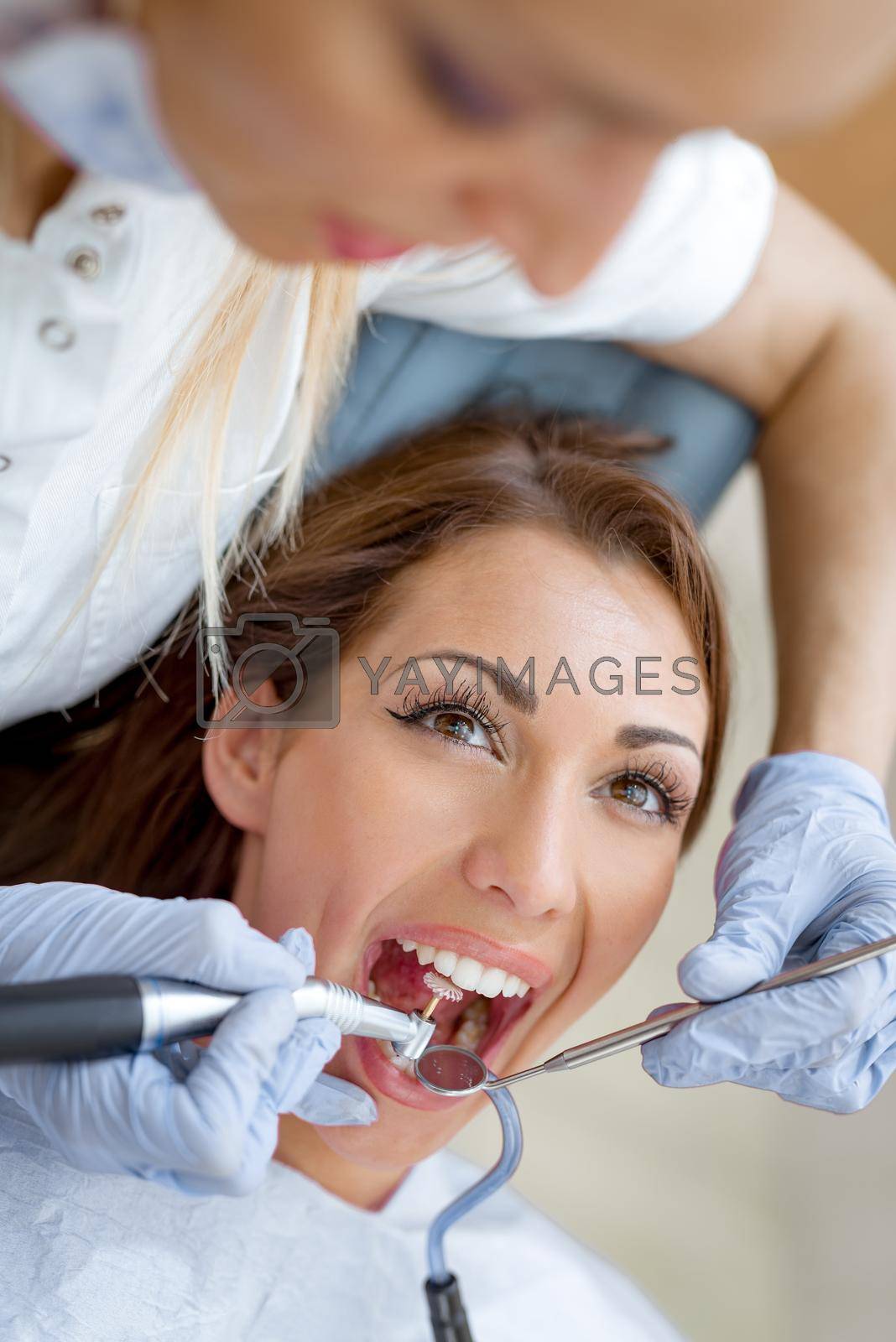Close- up of beautiful young woman in visit at the dentist office and dentist repair her teeth. 