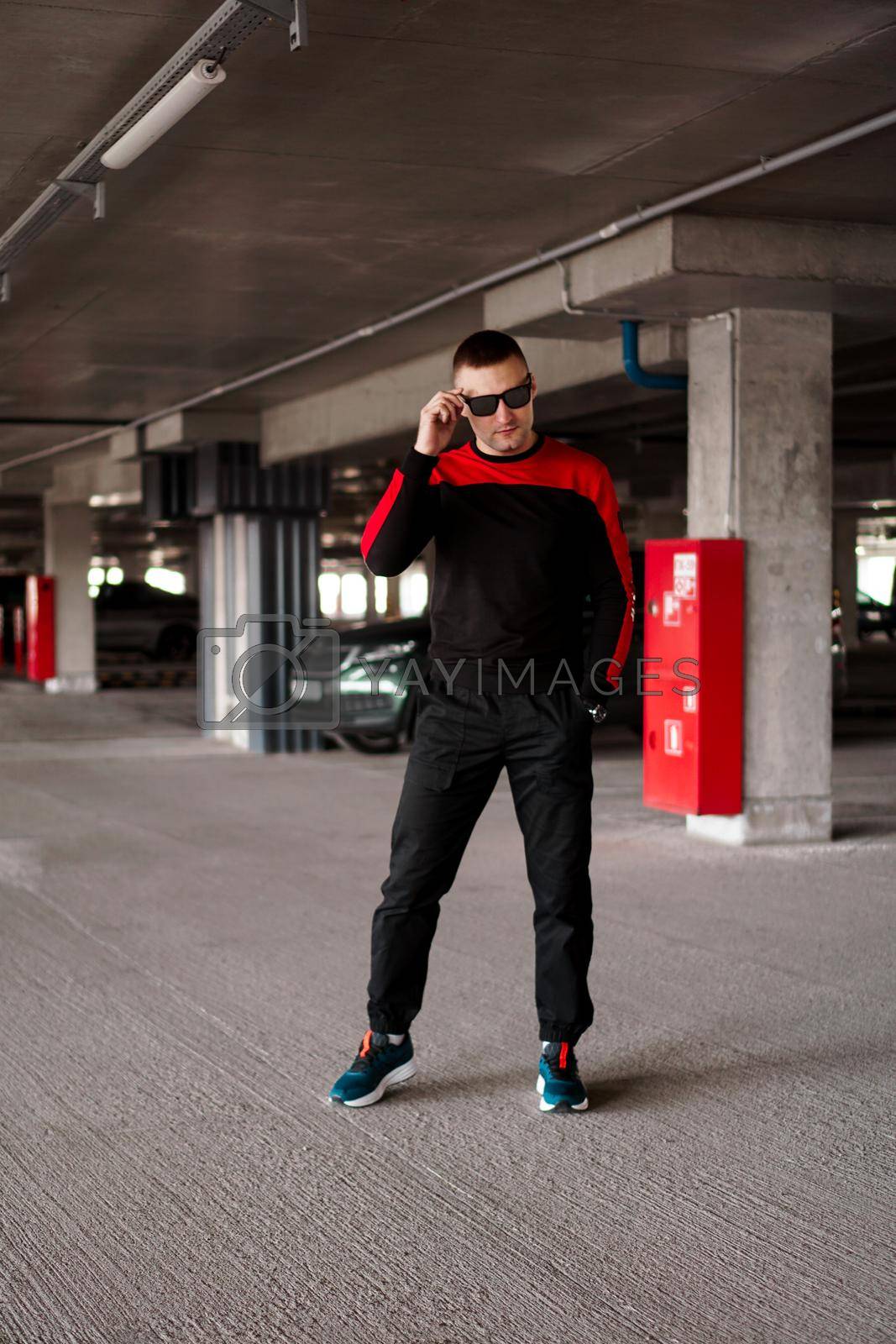 Royalty free image of A young man in a sports uniform in an underground parking lot. by natali_brill