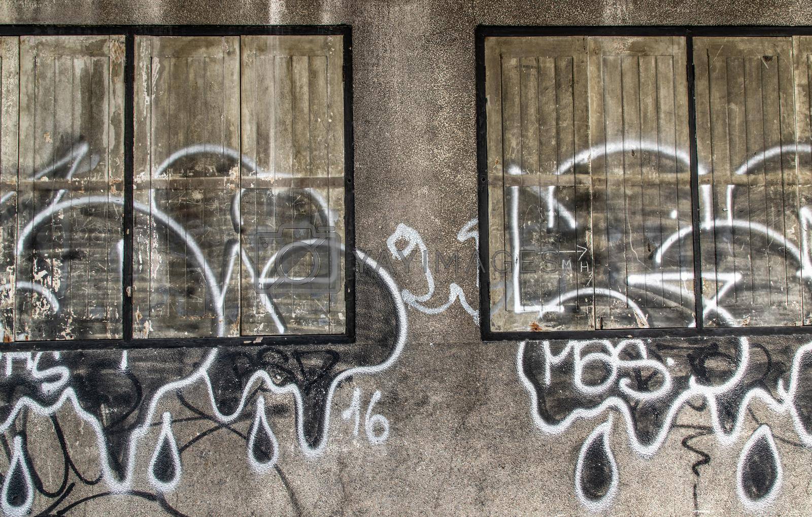 Royalty free image of Wood vintage window on the old wall and graffiti painting. by tosirikul