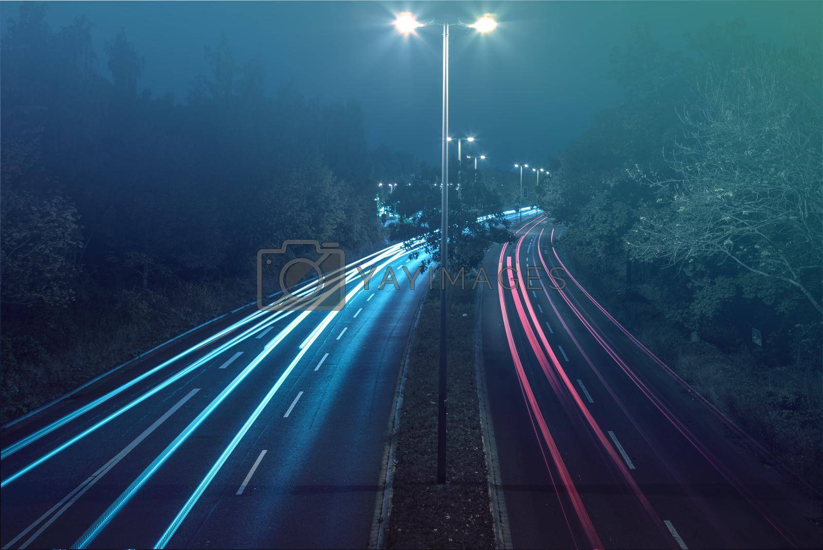 Royalty free image of Long-exposure shot of a four-lane road with luminescent lights at the approach by silent303