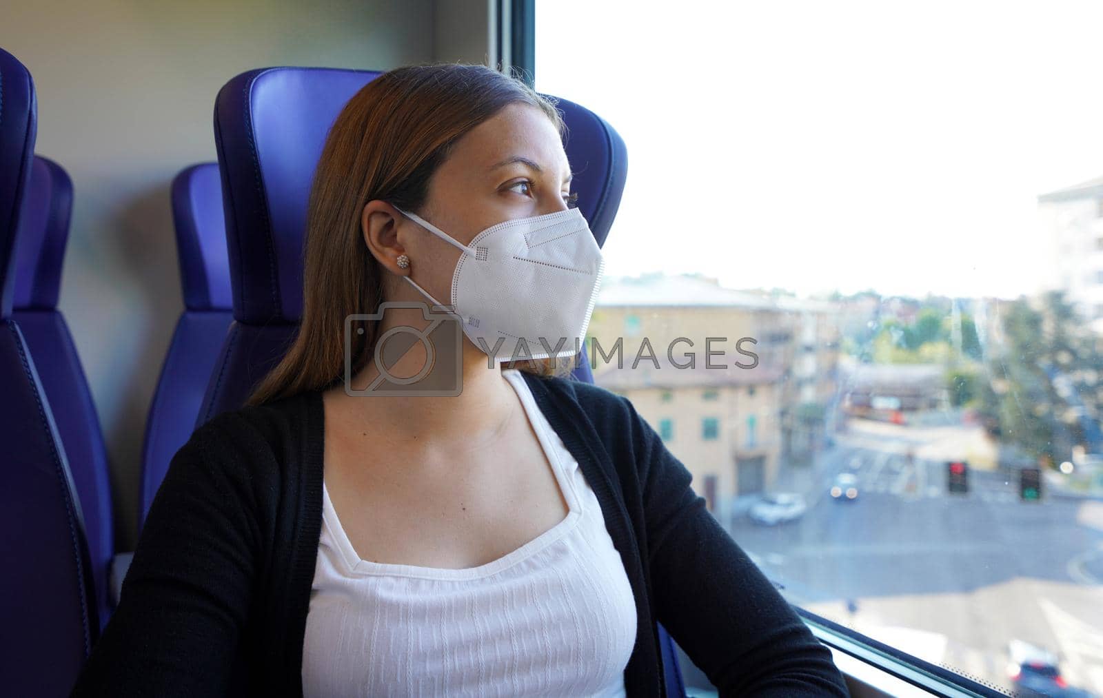Portrait of female commuter wearing protective mask FFP2 KN95 sitting on train