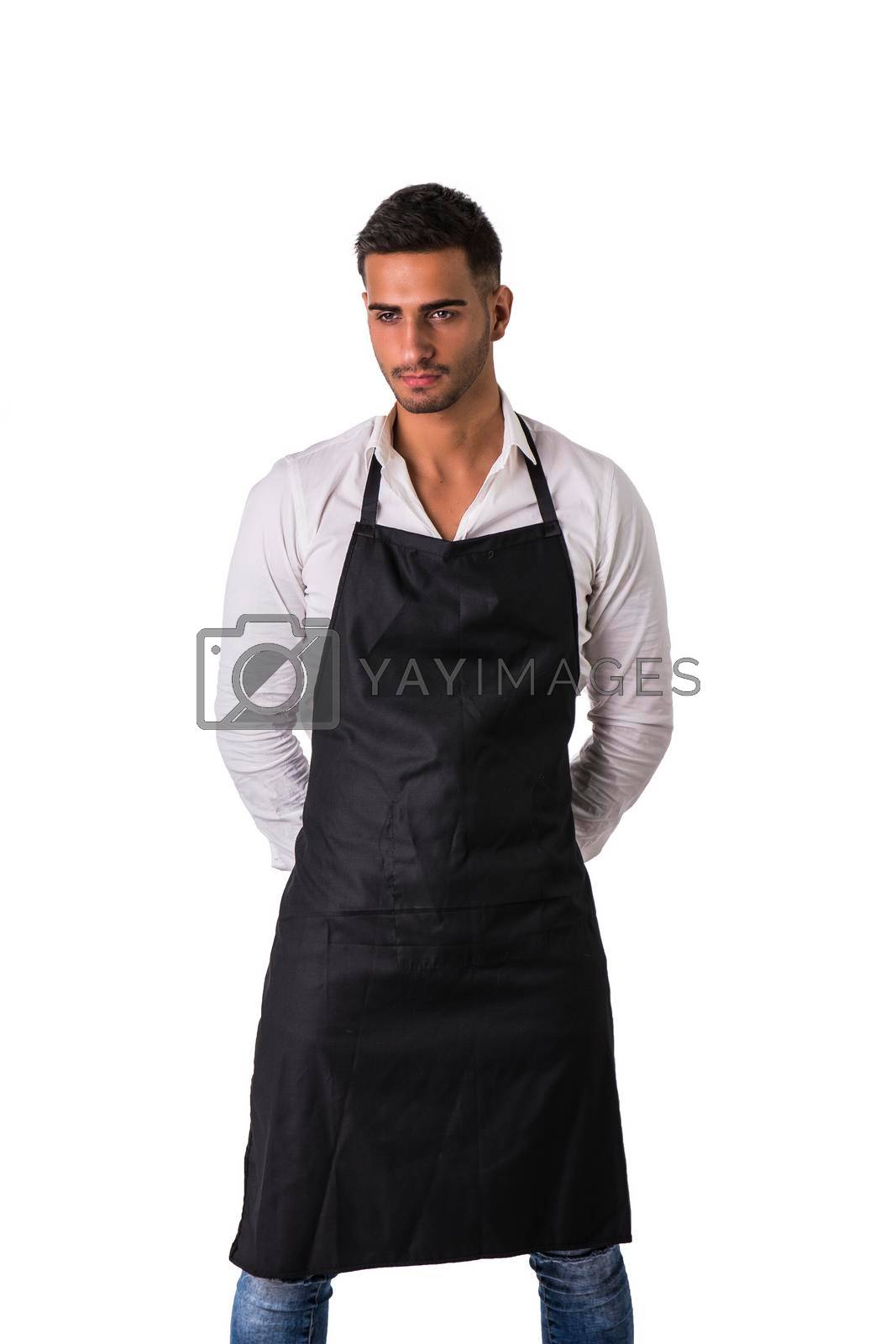 Royalty free image of Young chef or waiter wearing black apron by artofphoto