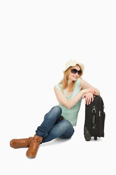 Woman smiling while sitting near a suitcase