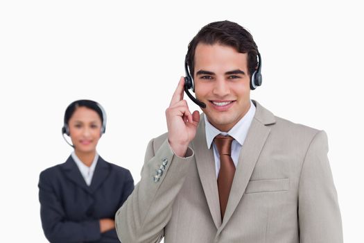Smiling hotline employee with co-worker behind him