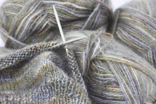 Woollen thread and knitting needle.