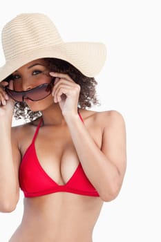 Young woman in beachwear putting on her sunglasses