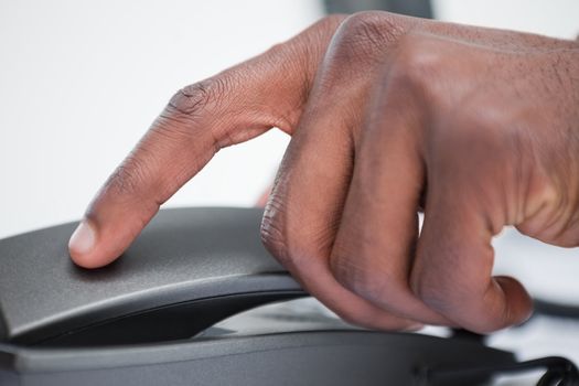 Close up of a masculine hand on a phone handset