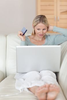 Woman on the sofa hunting bargain online