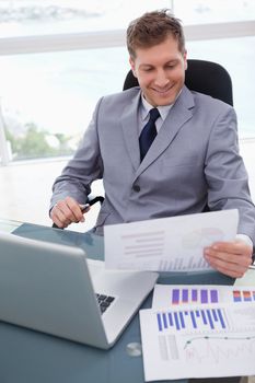 Smiling businessman looking at market research results