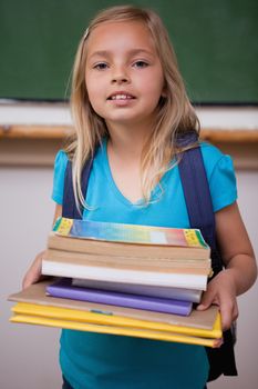 Portrait of a happy schoolgirl holding her books