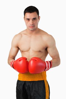 Young boxer with boxing gloves on against a white background