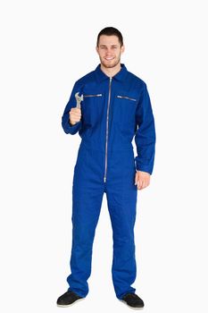 Smiling young mechanic in boiler suit with a wrench