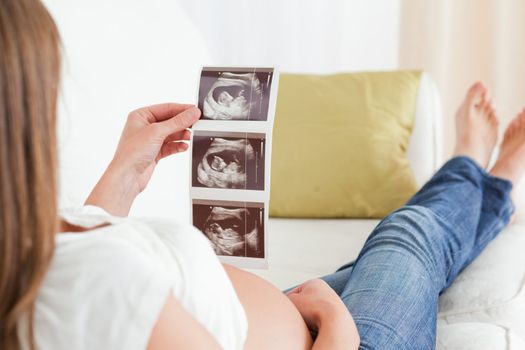 Beautiful pregnant woman looking at a sonography
