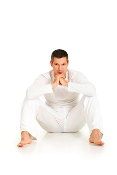 man dressed in white sitting on the floor