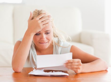 Blond woman in despair holding a letter