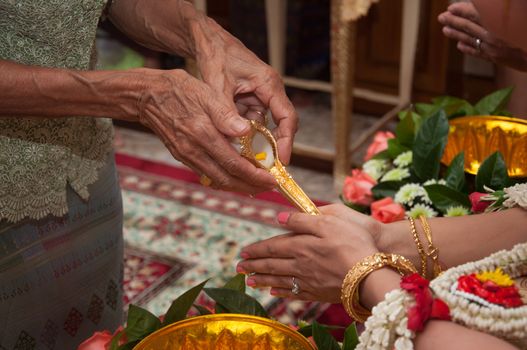 thai wedding ceremony - bride praying for holy water
