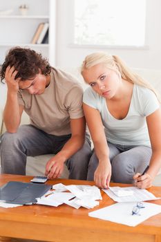 Despaired worn out couple calculating their expenses