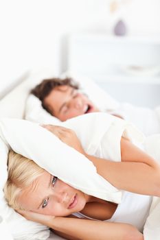Portrait of an unhappy woman awaken by her fiance's snoring