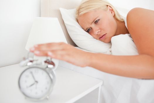 Unhappy woman awaken by an alarmclock