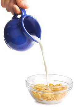 Milk flowing on a bowl of cornflakes