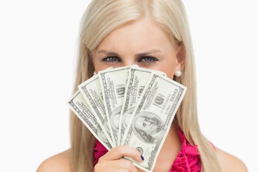 Blonde hiding her face with 100 dollars banknotes