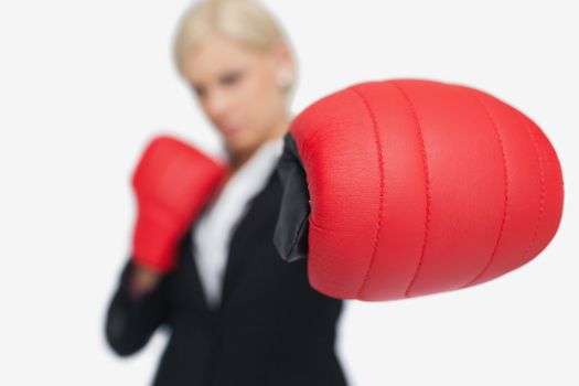 Blonde businesswoman with red boxing gloves fighting