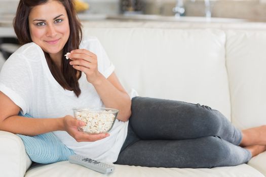 Woman eating popcorn and smiling