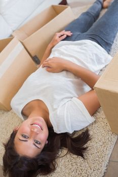 Woman lying betwen moving boxes