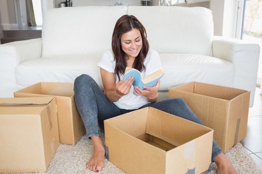 Woman looking at book from moving box