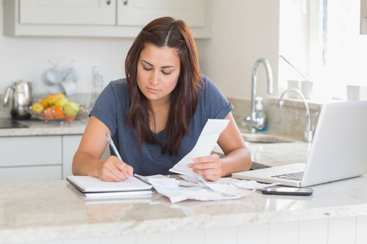 Woman calculating receipts with laptop 