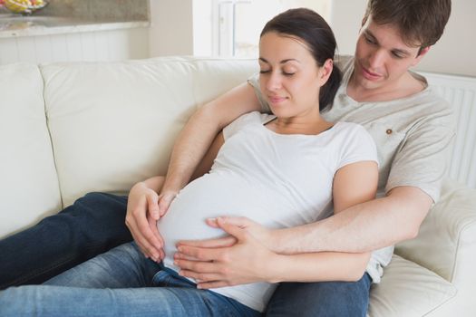Expectant parents relaxing on the couch